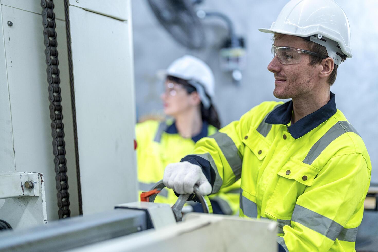 Male and female engineers in neat work clothes prepare and control the production system of large modern machines in a factory producing industrial technology products. photo