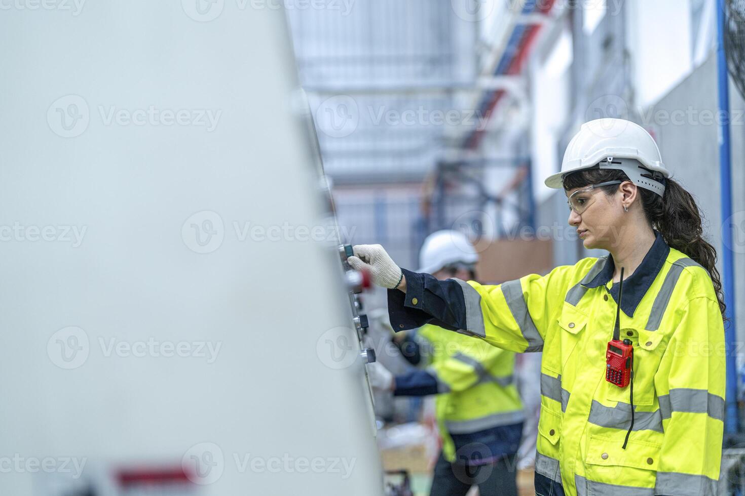 Male and female engineers in neat work clothes prepare and control the production system of large modern machines in a factory producing industrial technology products. photo