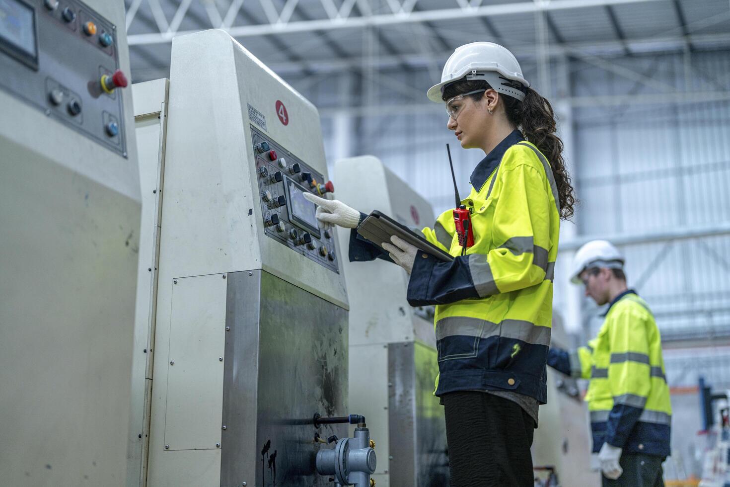 Male and female engineers in neat work clothes prepare and control the production system of large modern machines in a factory producing industrial technology products. photo