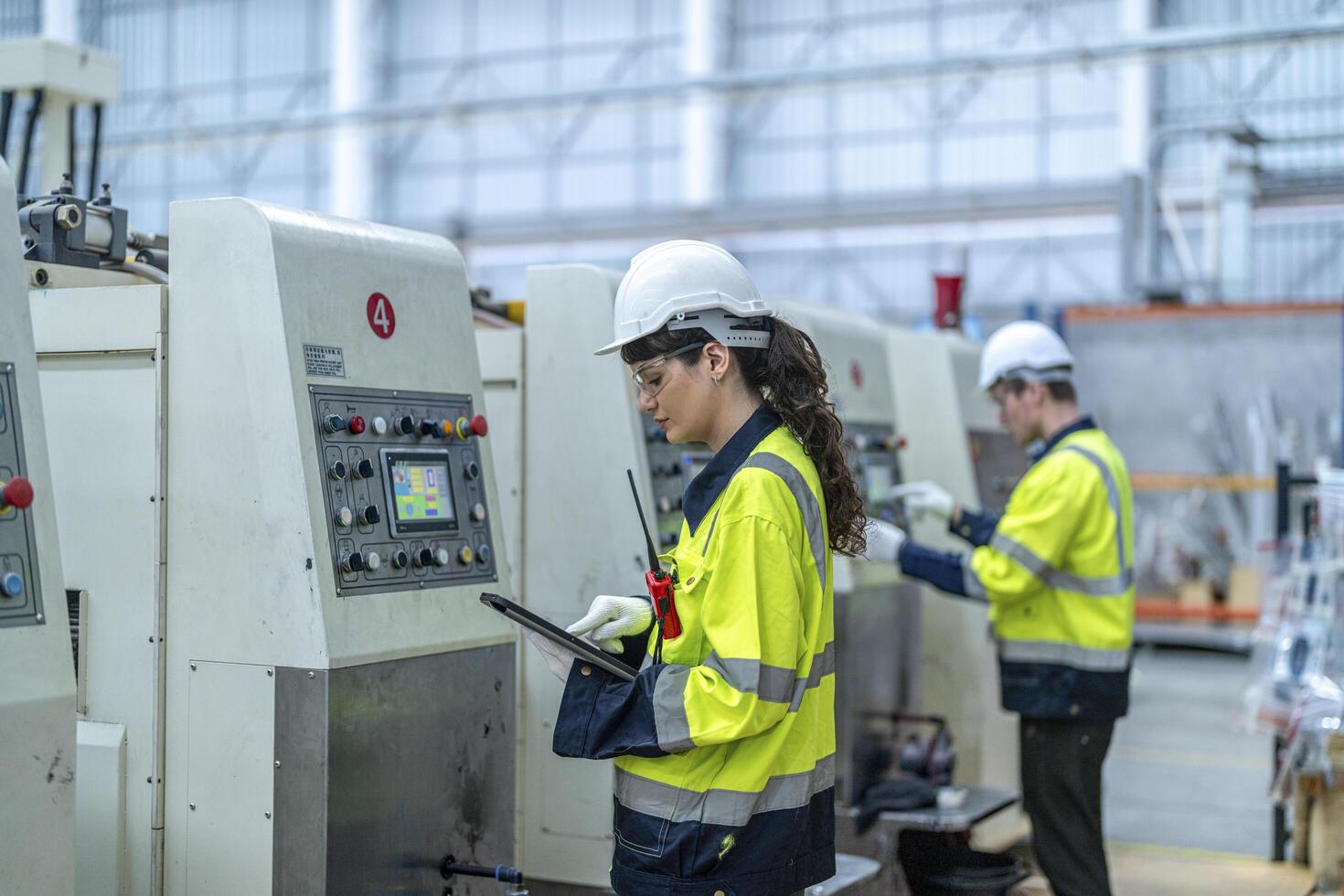 Male and female engineers in neat work clothes prepare and control the production system of large modern machines in a factory producing industrial technology products. photo