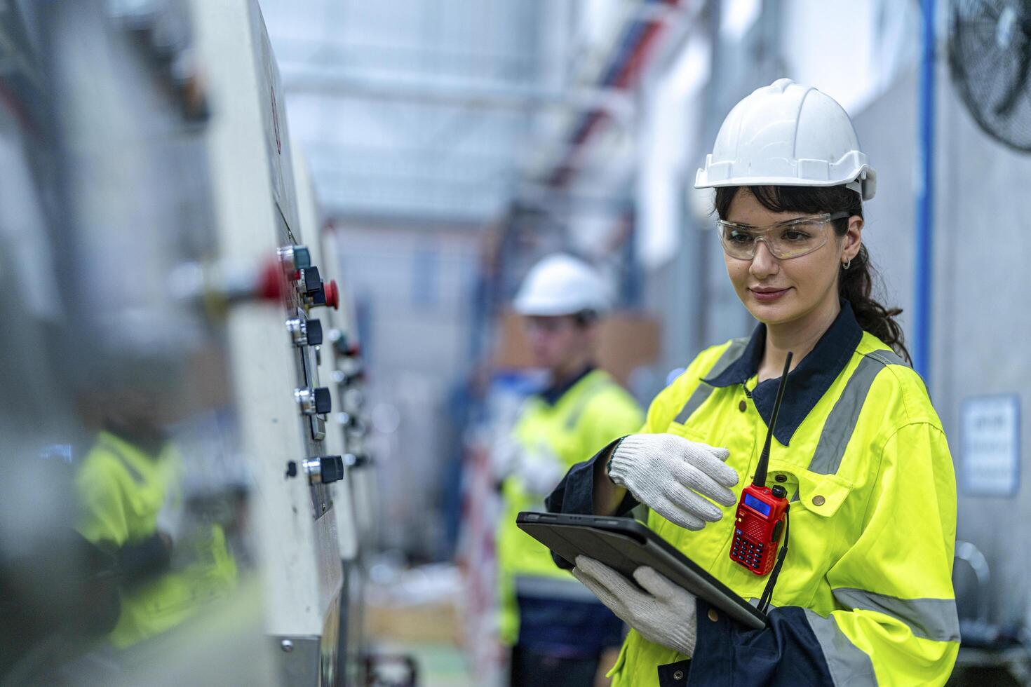 Male and female engineers in neat work clothes prepare and control the production system of large modern machines in a factory producing industrial technology products. photo