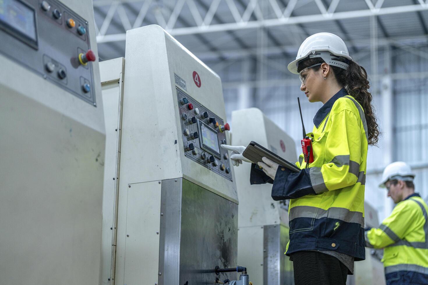 Male and female engineers in neat work clothes prepare and control the production system of large modern machines in a factory producing industrial technology products. photo
