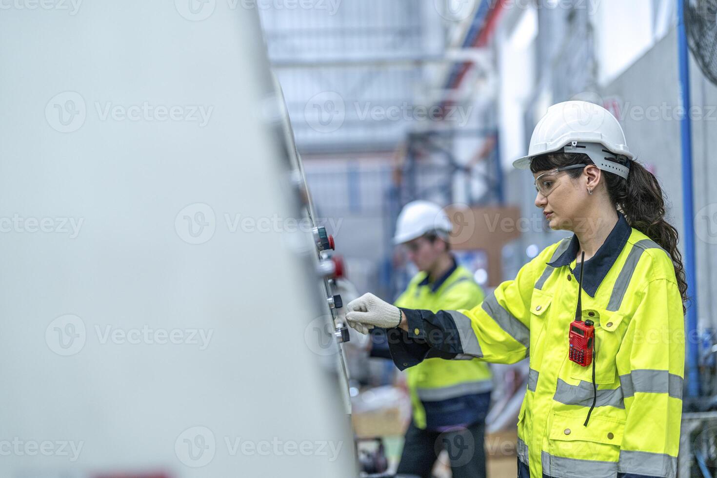 Male and female engineers in neat work clothes prepare and control the production system of large modern machines in a factory producing industrial technology products. photo