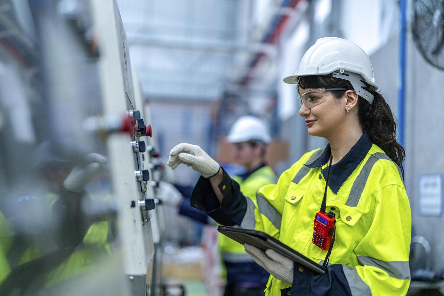Male and female engineers in neat work clothes prepare and control the production system of large modern machines in a factory producing industrial technology products. photo