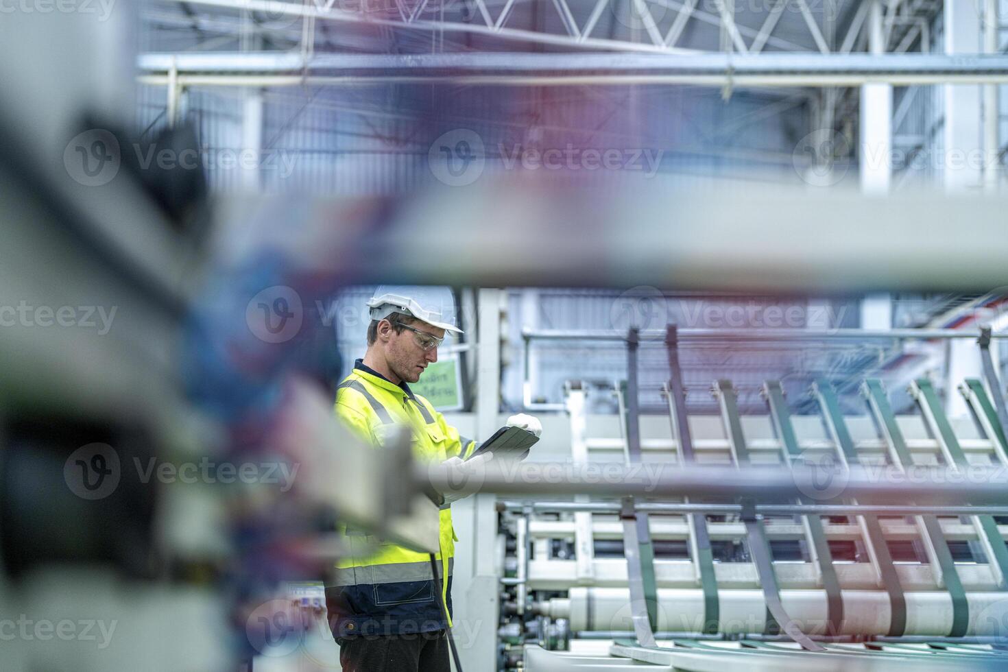 Male and female engineers in neat work clothes prepare and control the production system of large modern machines in a factory producing industrial technology products. photo