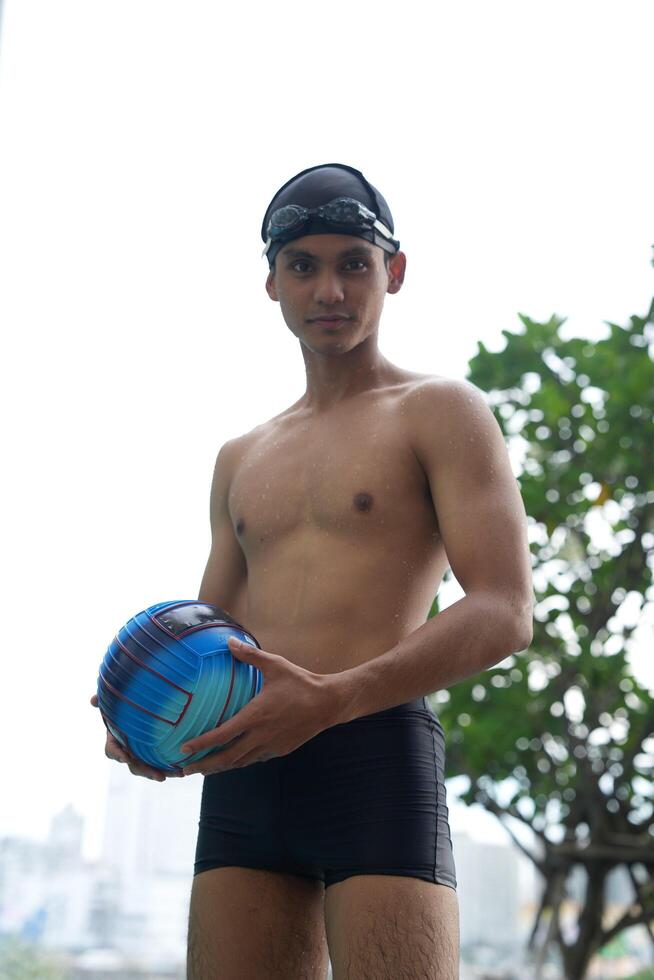Asian men practicing swimming and preparing to play water polo and stretching and resting for water sports. photo