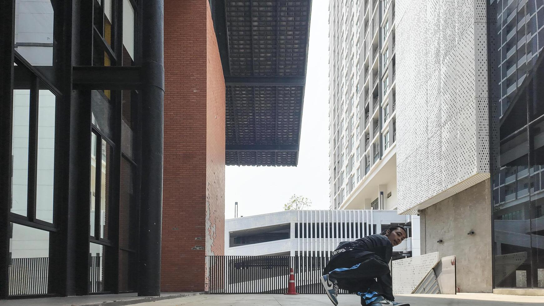 ASian man is dancing in hip hop style at outdoor space. Professional solo dancer is performing in public area. photo