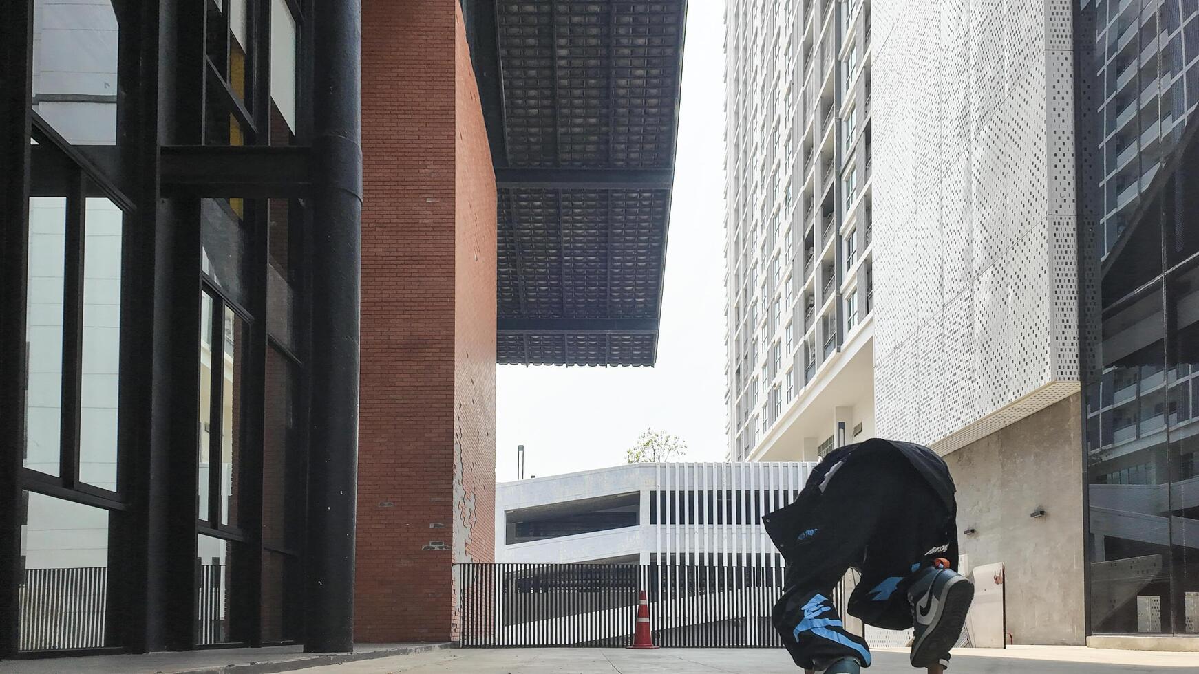 ASian man is dancing in hip hop style at outdoor space. Professional solo dancer is performing in public area. photo