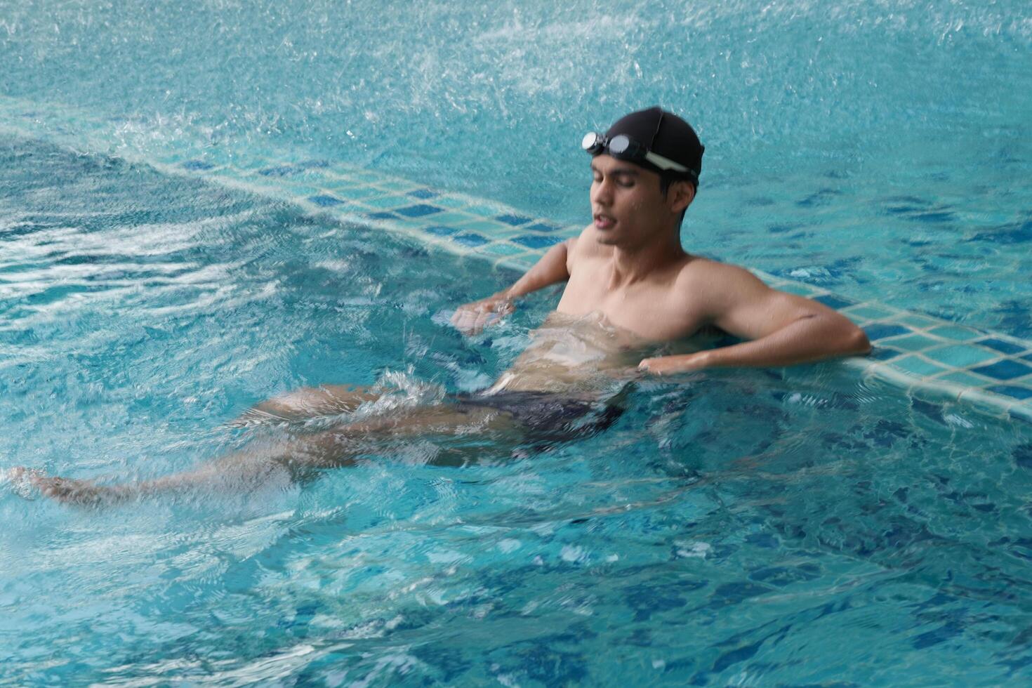 Asian men practicing swimming and preparing to play water polo and stretching and resting for water sports. photo