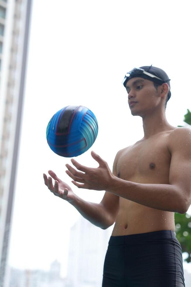Asian men practicing swimming and preparing to play water polo and stretching and resting for water sports. photo