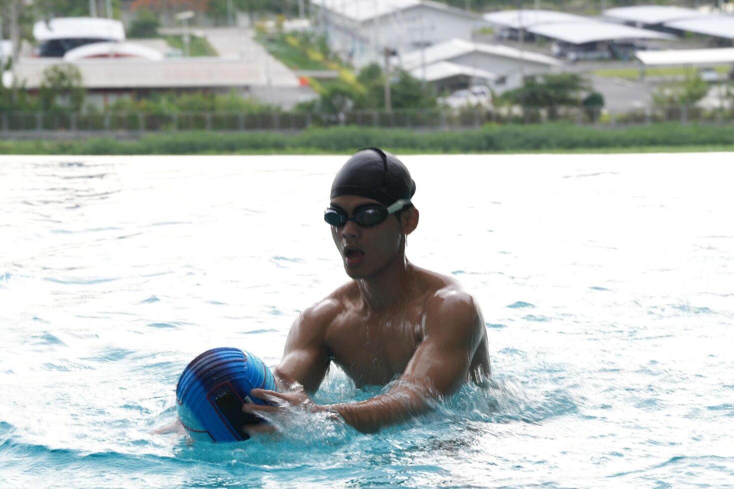 Asian men practicing swimming and preparing to play water polo and stretching and resting for water sports. photo