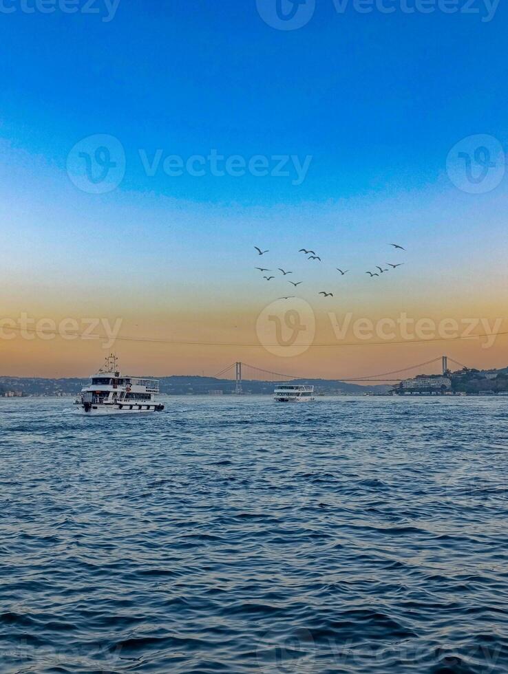 a boat is in the water with birds flying around it. Bosphorus Istanbul Turkey photo