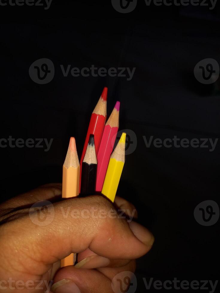 holding colored pencils in hand photo