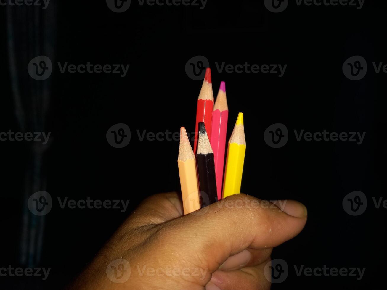 holding colored pencils in hand photo