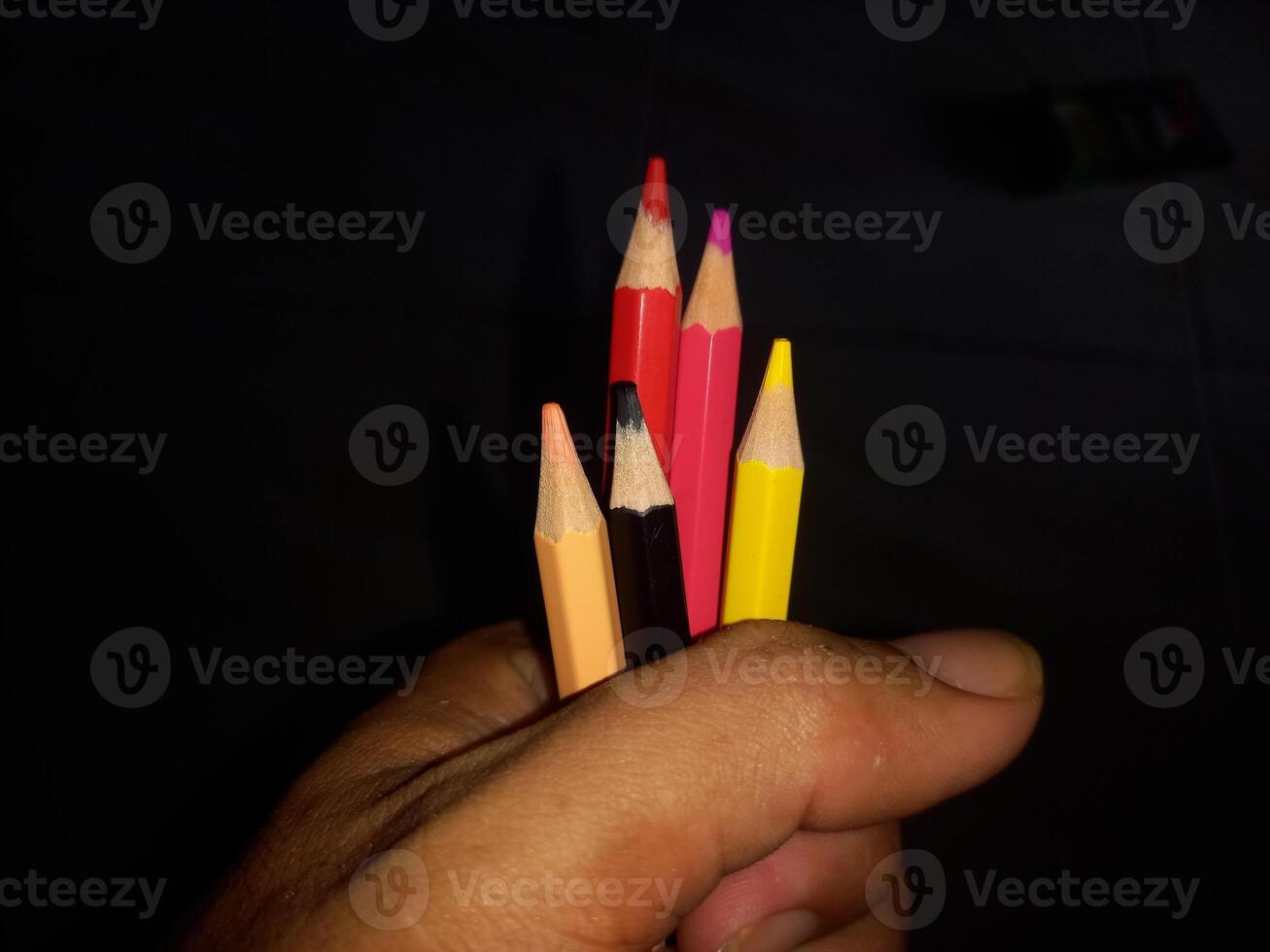 holding colored pencils in hand photo