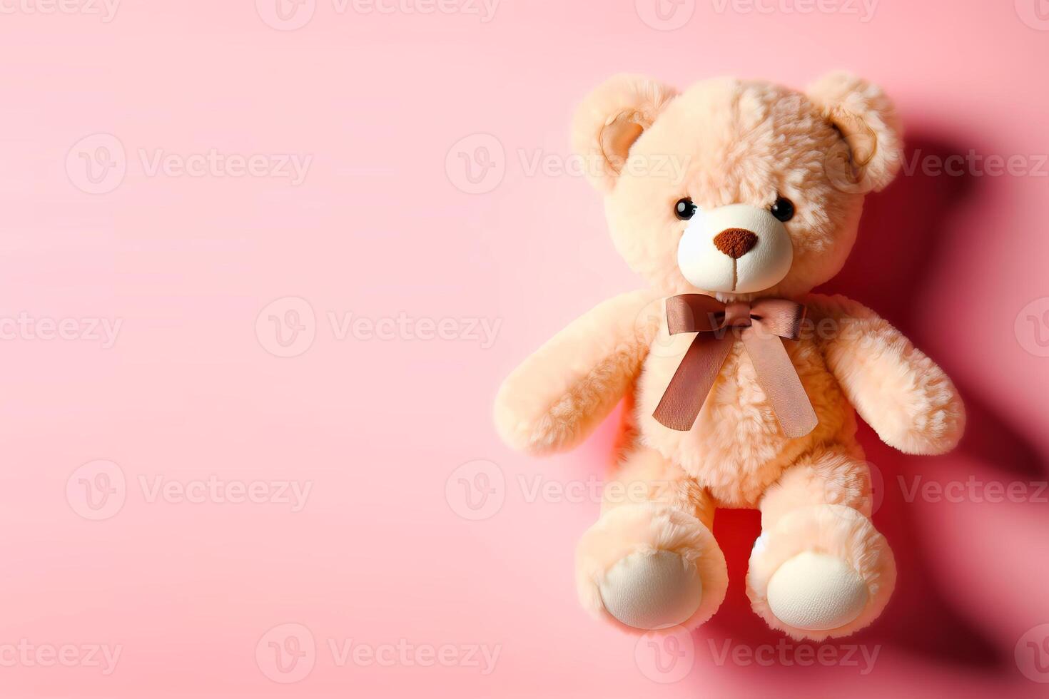 stuffed teddy bear toy on pink background with place for text photo