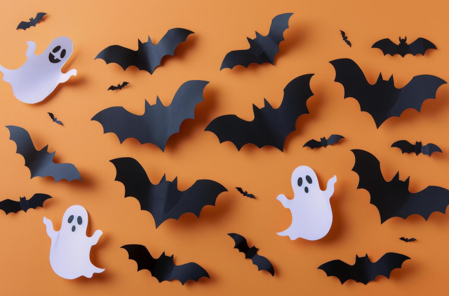 Paper Bat and Ghost Decorations on Orange Background for Halloween photo