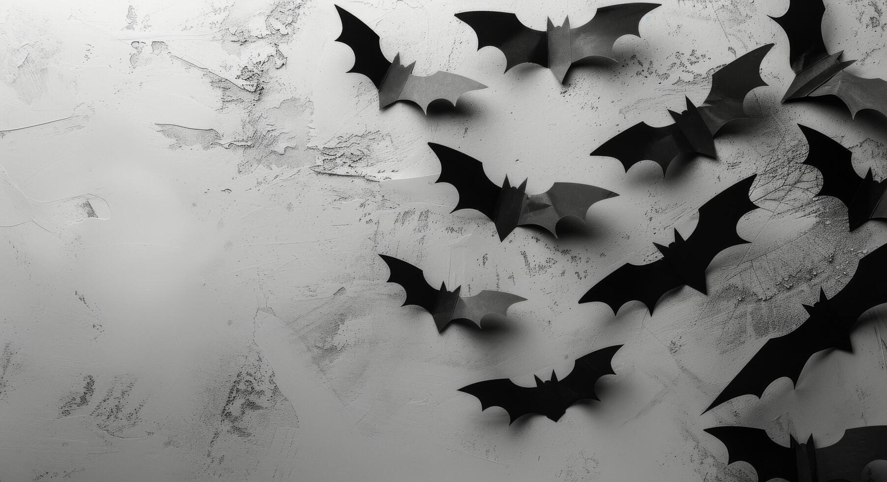 Black Paper Bats Decorated on a Cracked White Wall photo