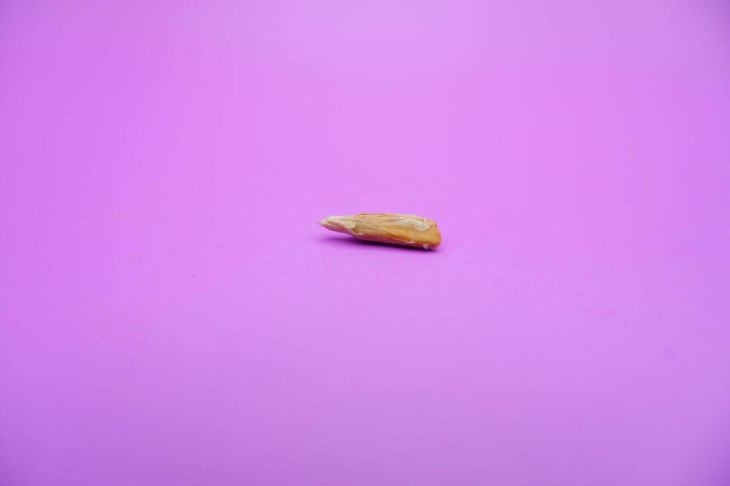 peeled sunflower seeds snack isolated on a purple background photo