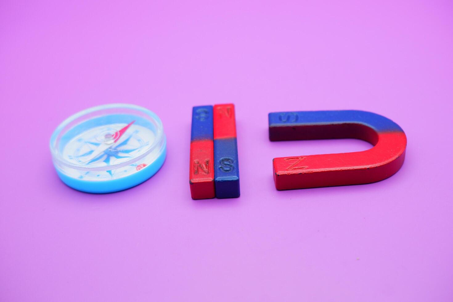 magnet and compass isolated on purple background photo