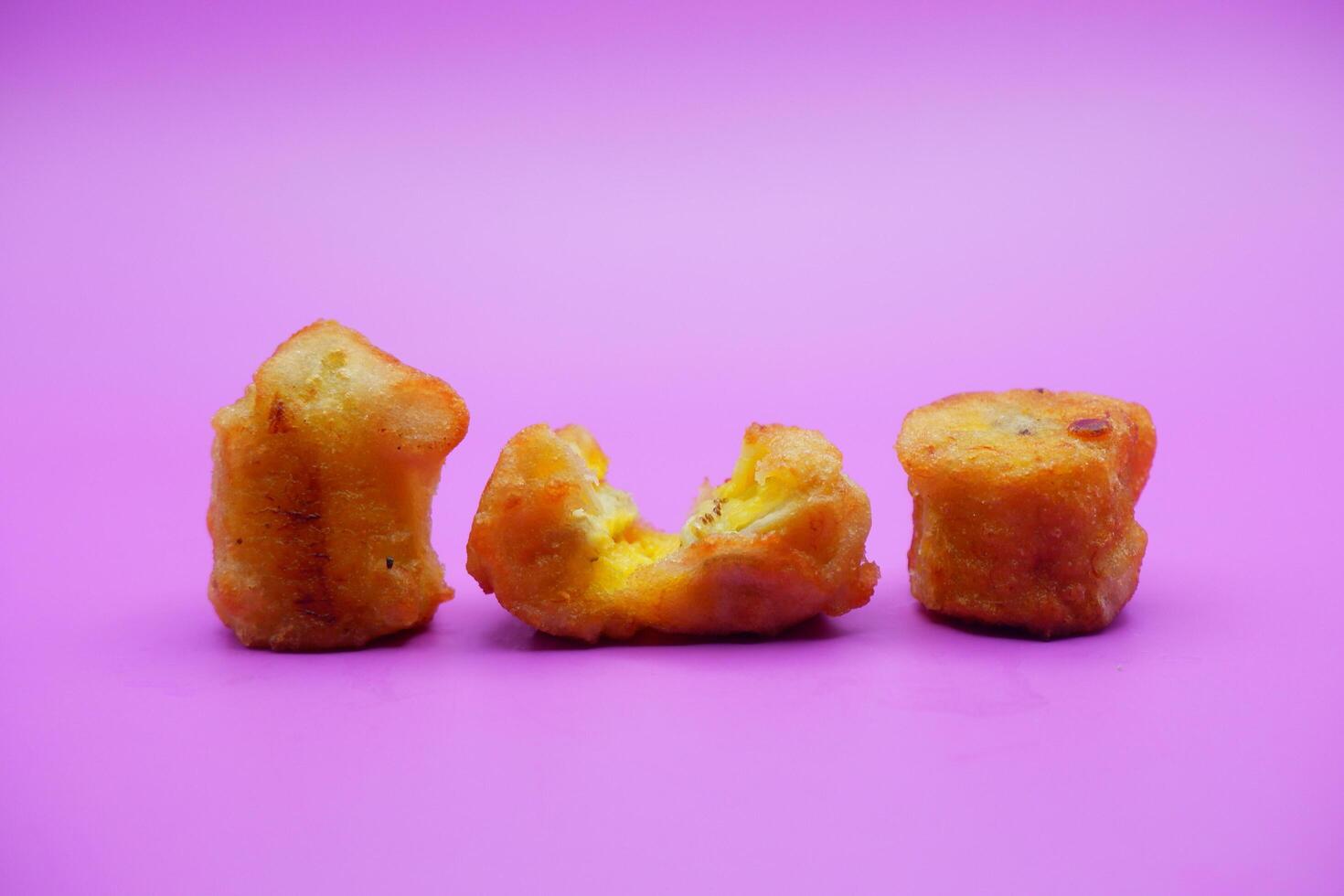 3 fried bananas isolated on purple background photo