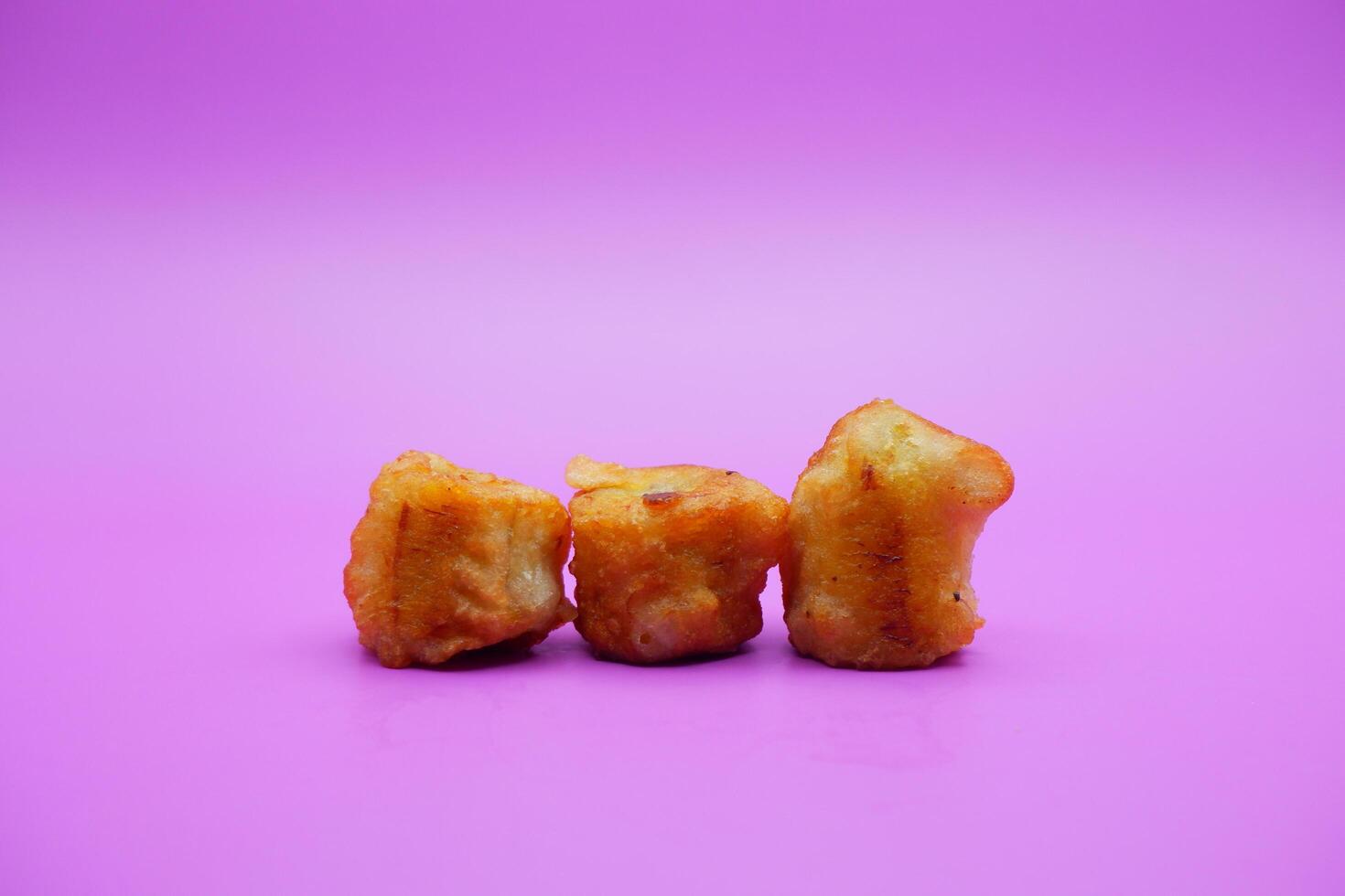 3 fried bananas isolated on purple background photo