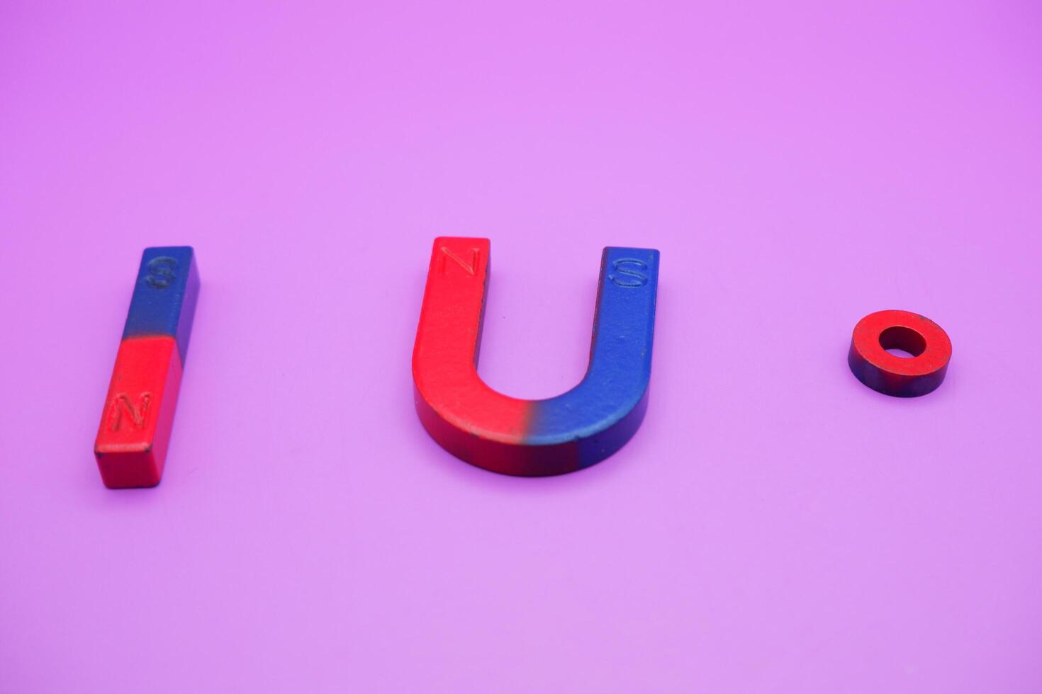 various shapes of magnets isolated on a purple background photo