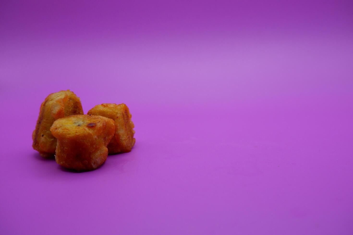 3 fried bananas isolated on purple background photo