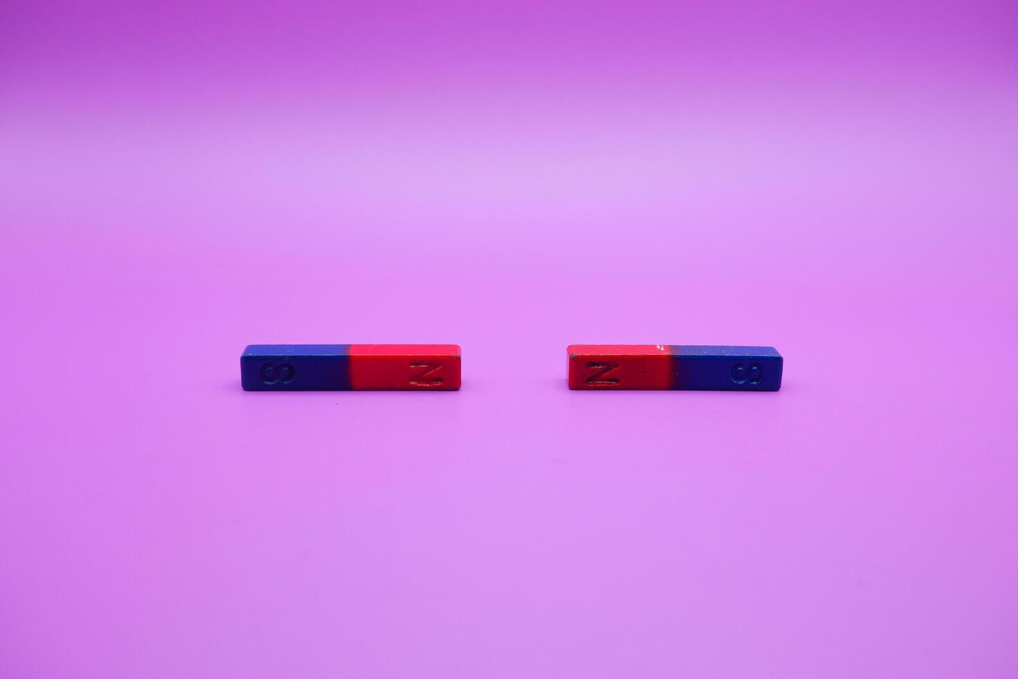 two bar magnets isolated on a purple background photo