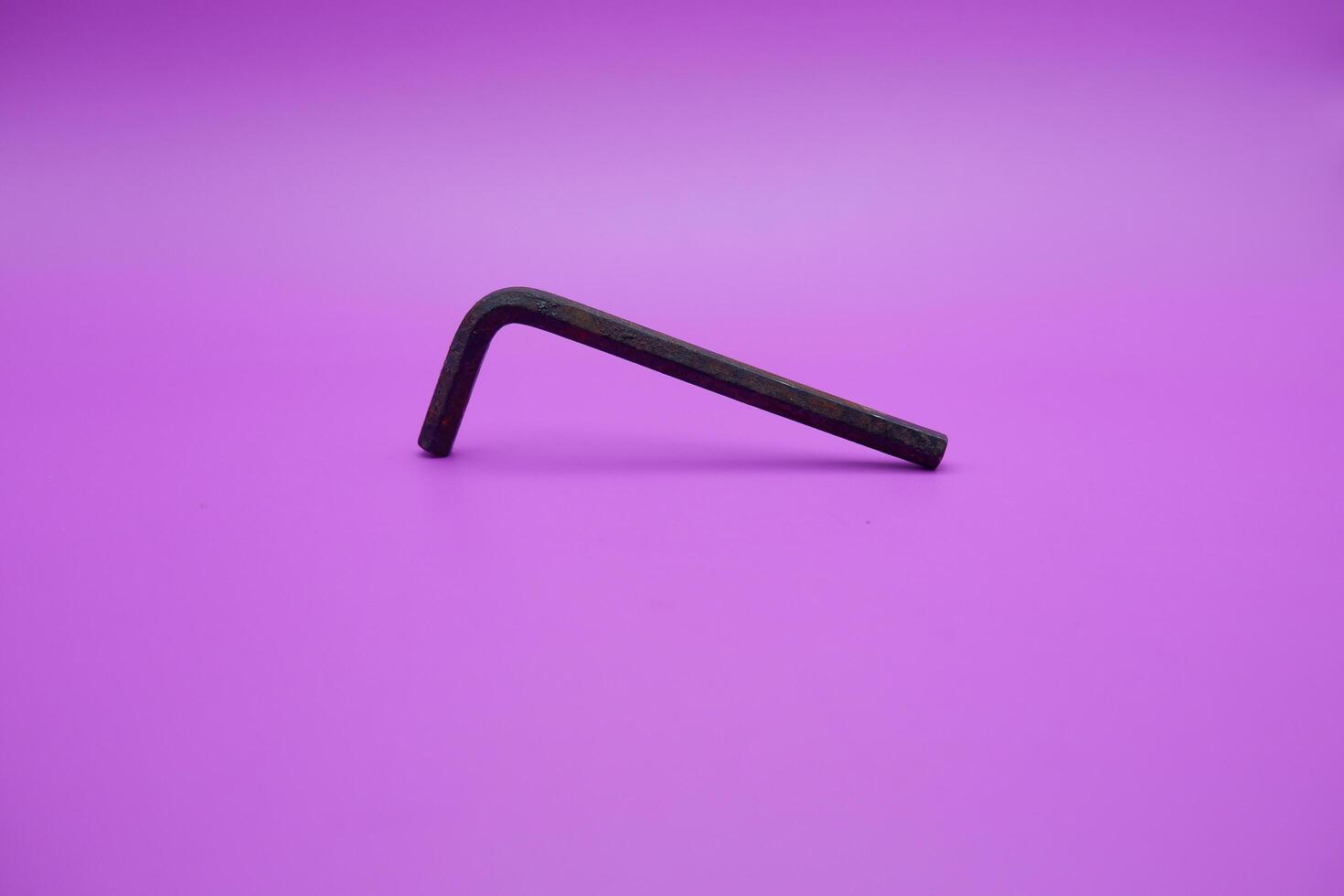 Allen key isolated purple background. a black L key. photo
