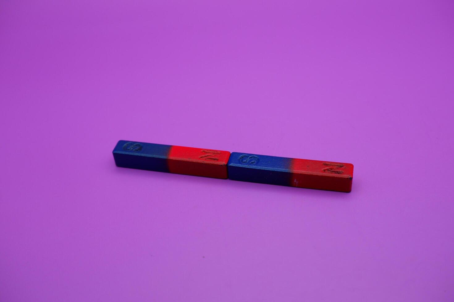 two bar magnets isolated on a purple background photo