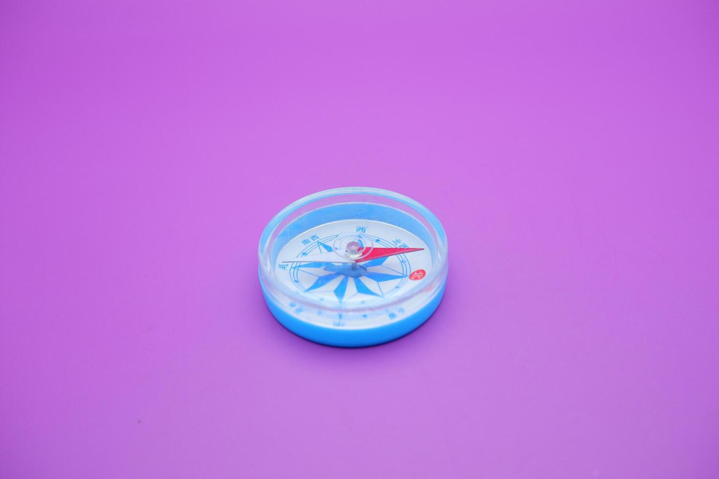 round compass isolated on purple background. photo