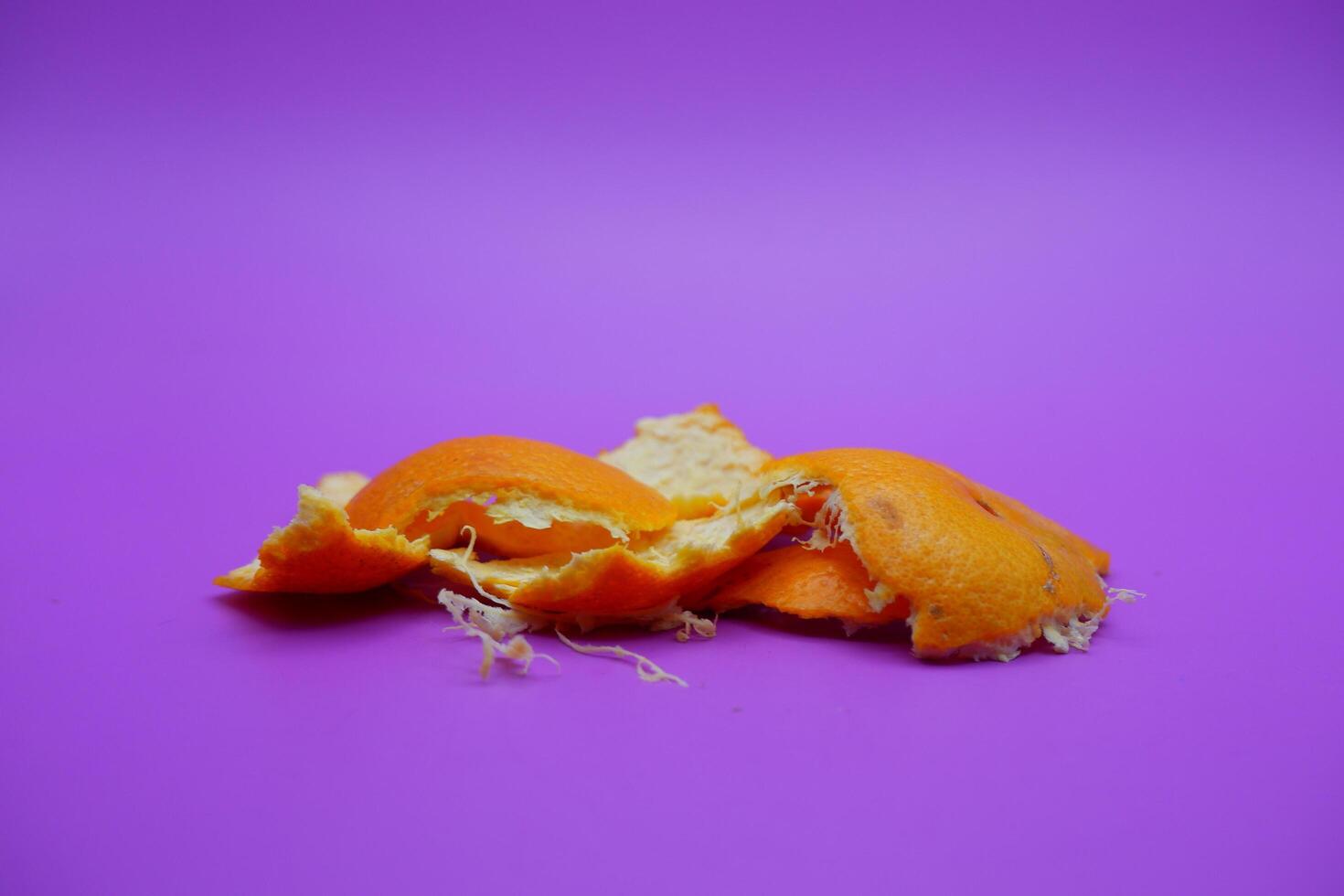 Orange peel isolated on purple background photo