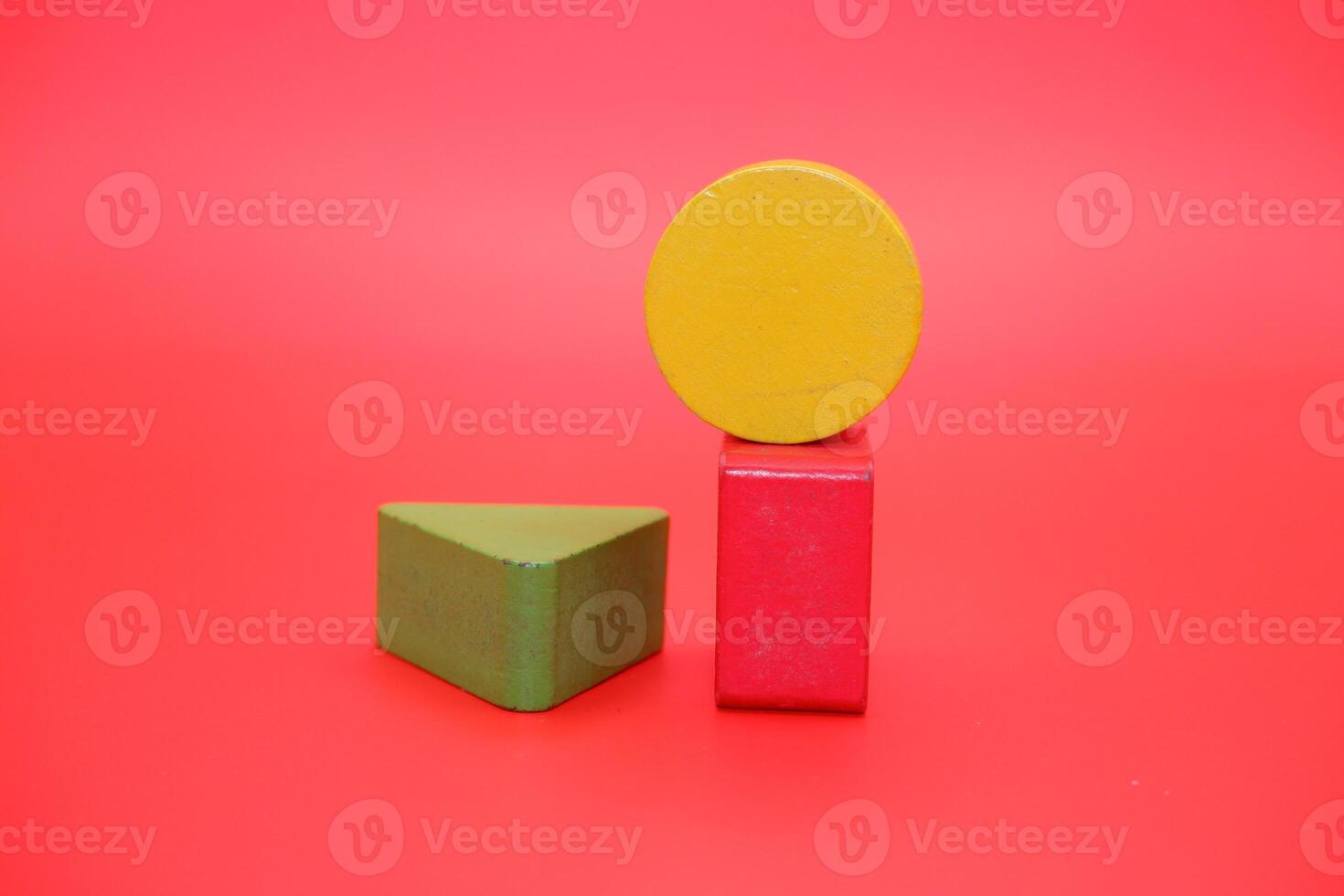 colorful wooden toys isolated red background. wooden toys shaped like triangles, squares and circles. photo