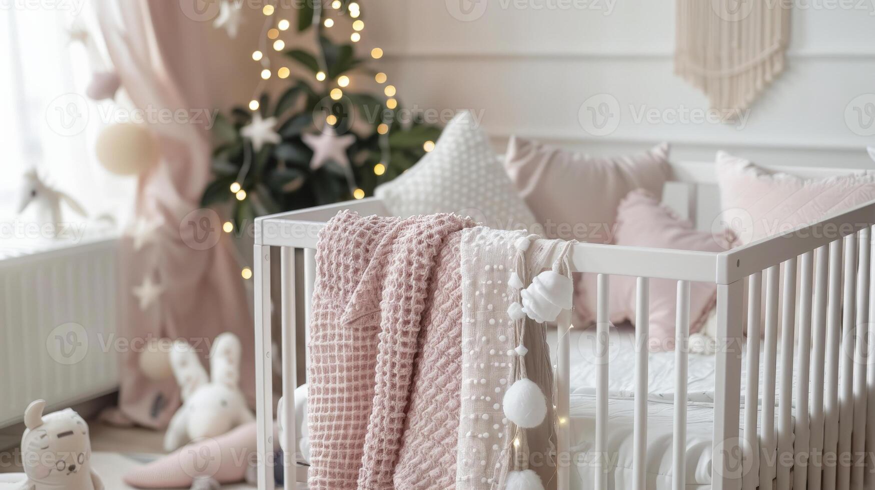 A baby crib adorned with pink blankets and pillows in a white nursery photo