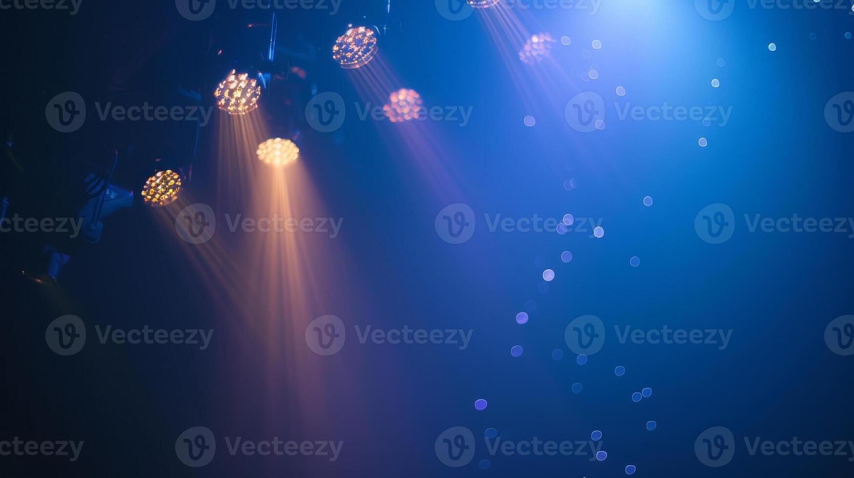A close-up view of stage lights casting beams of light in a dark venue photo