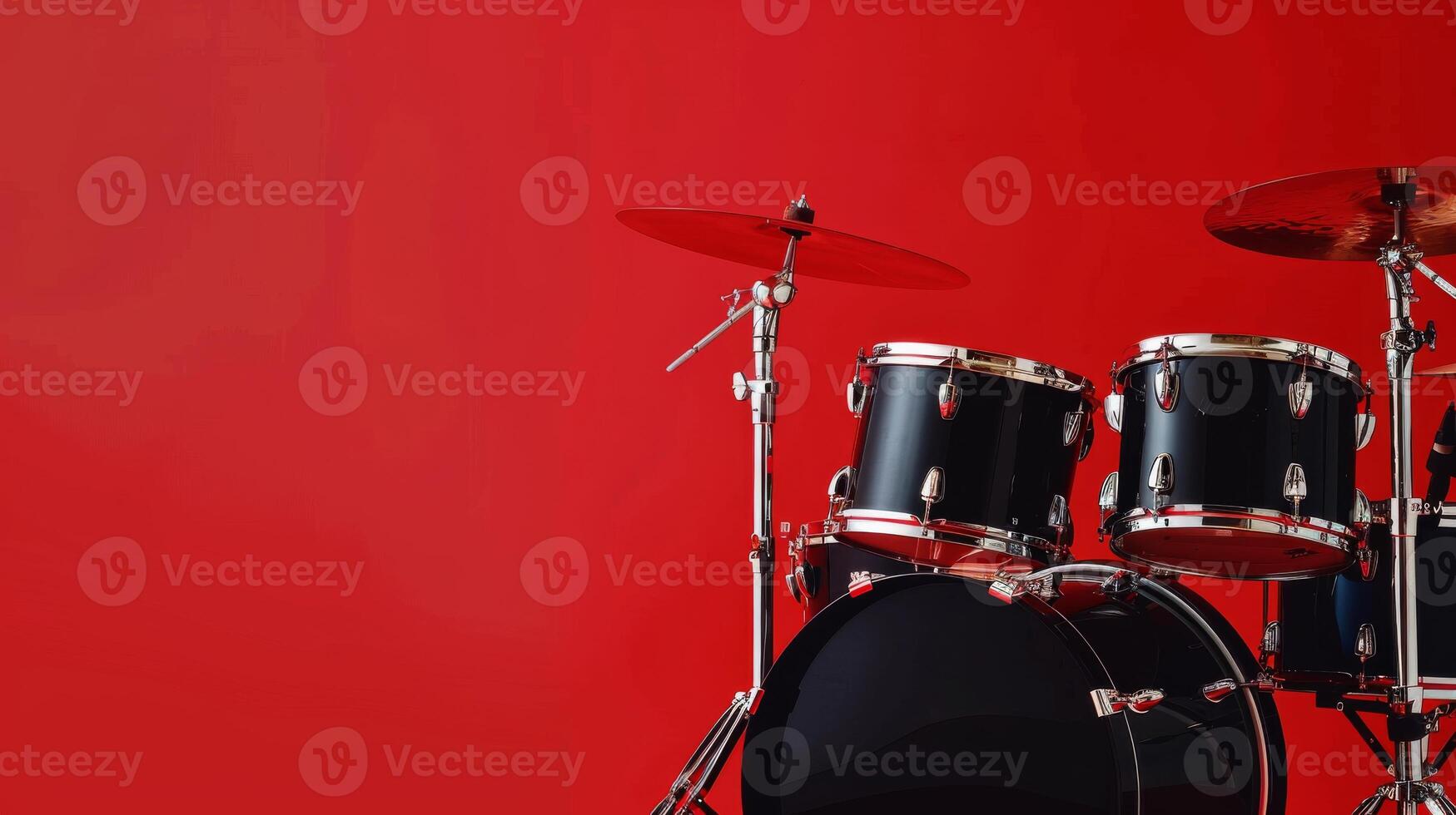 A close-up of a black drum set with cymbals against a red background photo