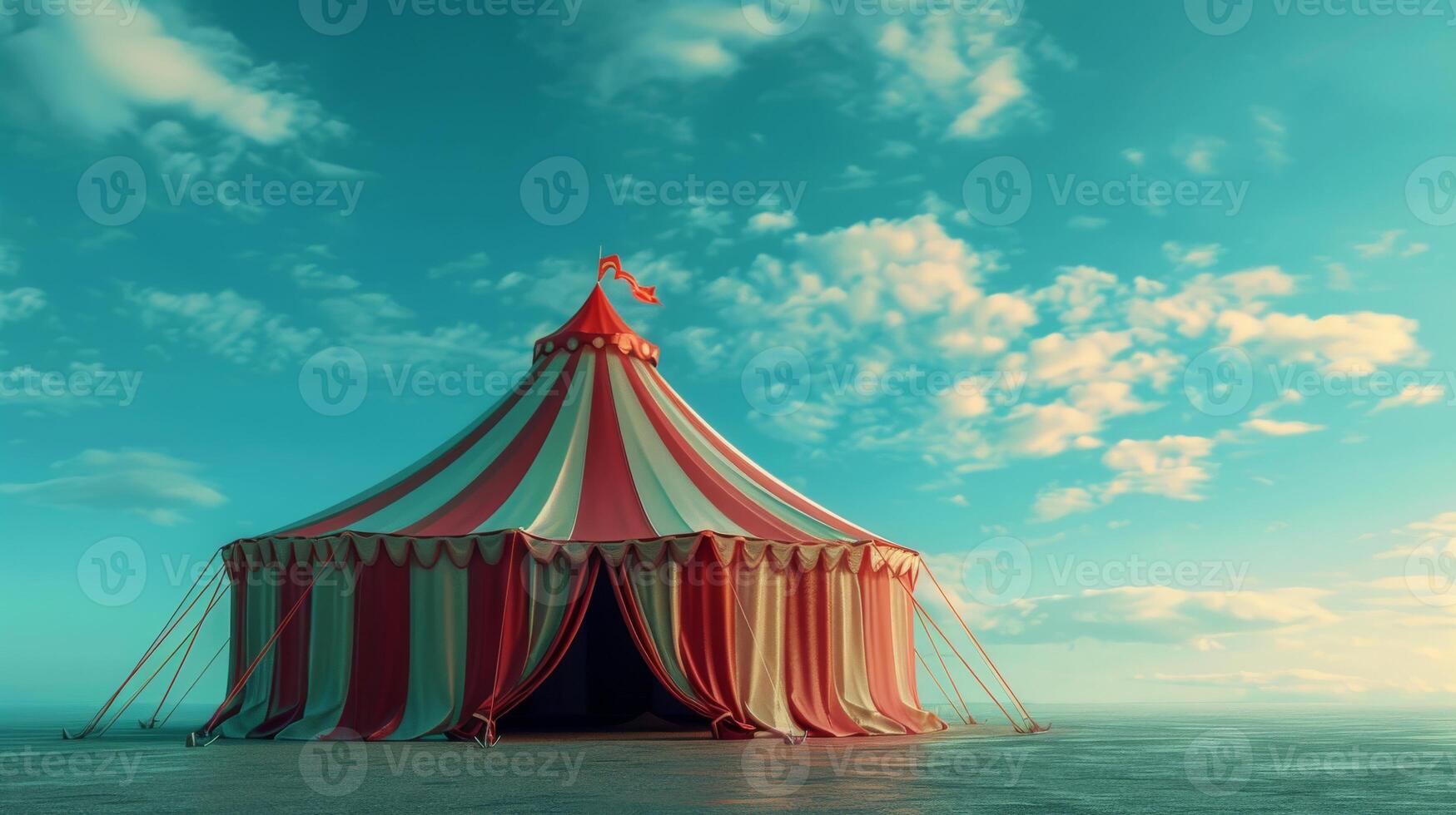 A red and white striped circus tent stands on a beach under a blue sky photo