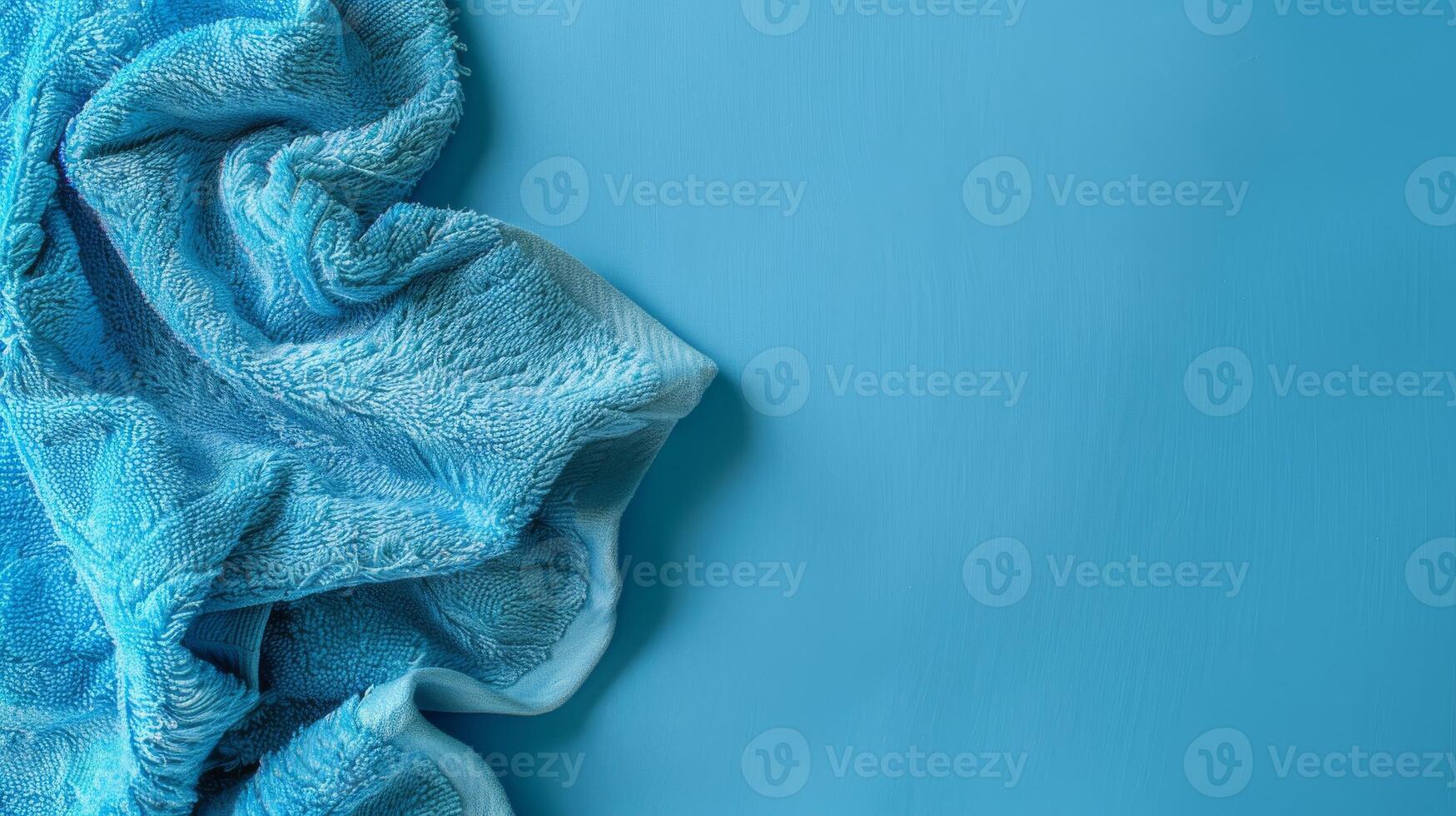 A soft blue towel sits on a blue background photo