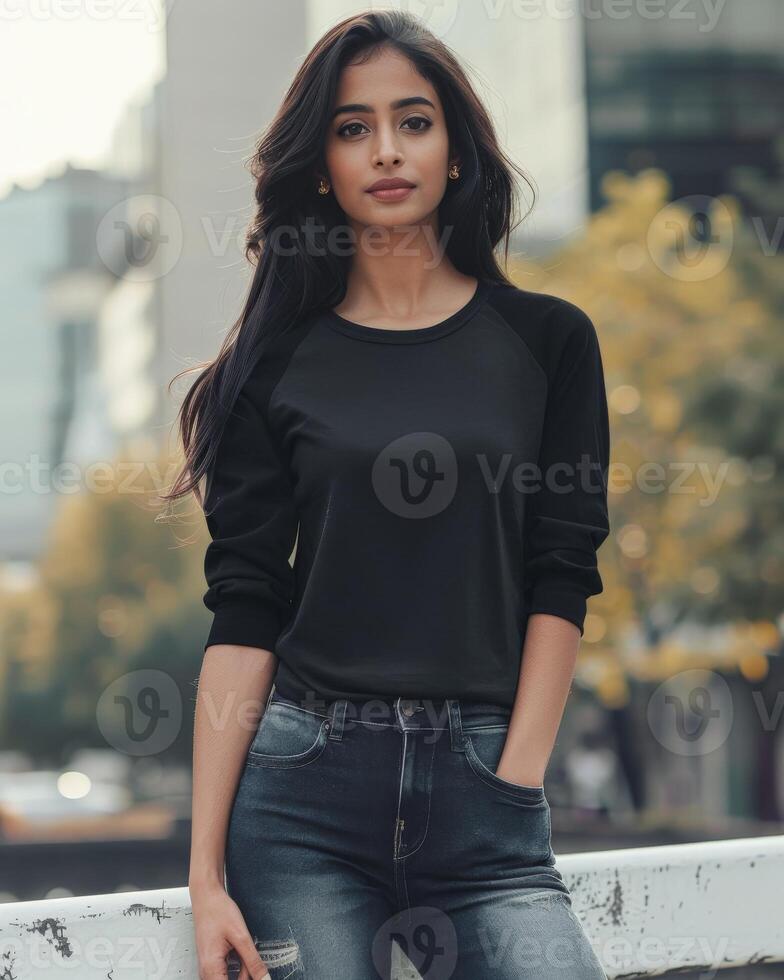 Woman in black raglan shirt, jeans, and city backdrop photo