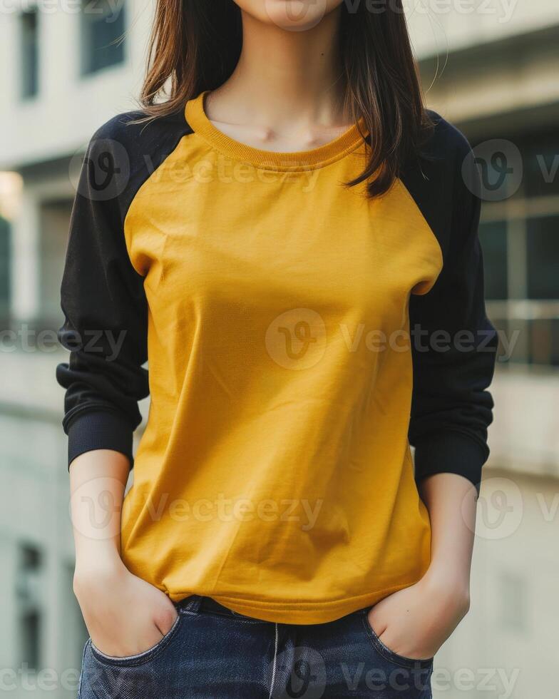 A young woman wears a mockup of a yellow and black raglan shirt photo