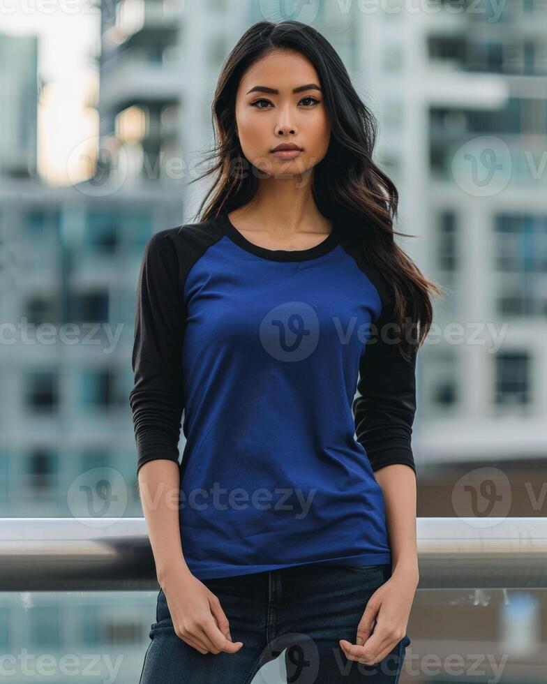 Female model wearing a blue and black raglan shirt in an urban environment photo