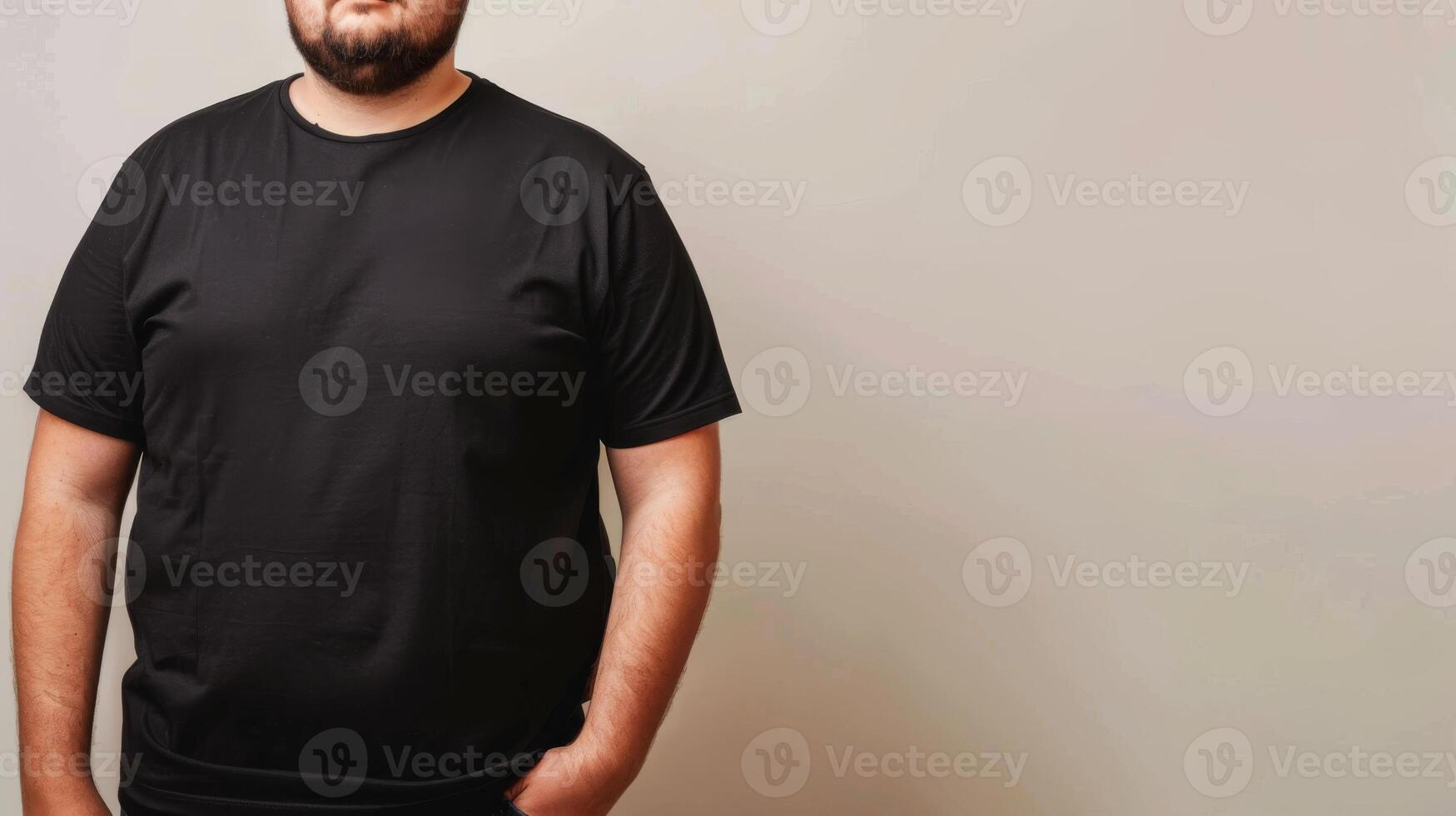 A man wearing a plain black t-shirt stands against a simple, off-white backdrop photo