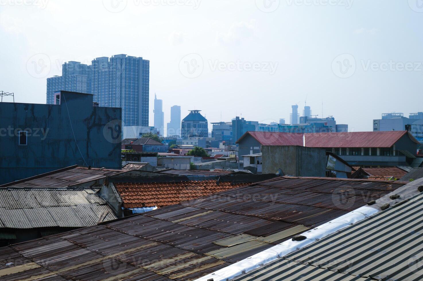 View of dense rooftops in Jakarta with tall buildings in the background photo