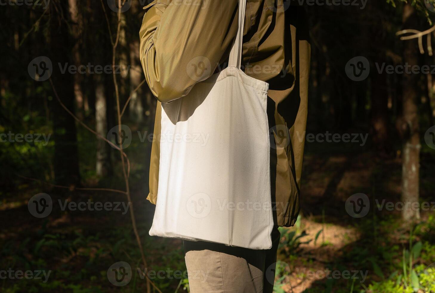 . Canvas tote bag on male shoulder, nature forest background photo