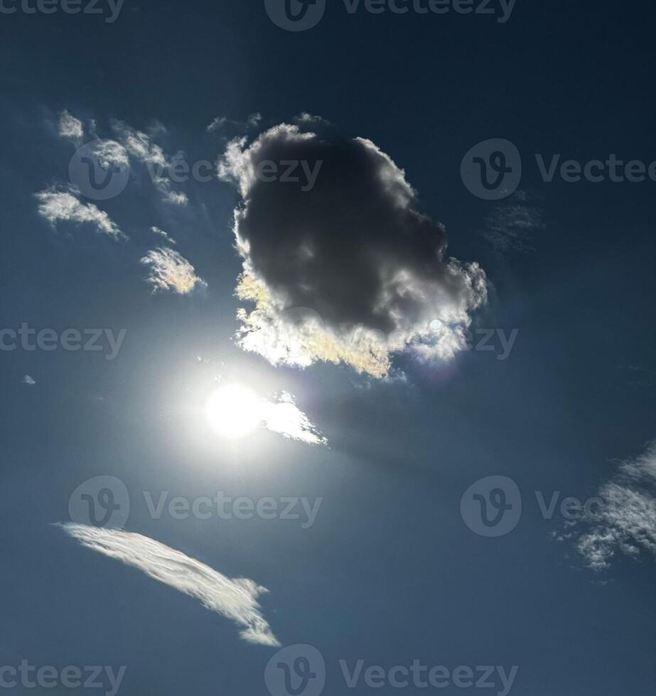 The Sun is Shining Through the Clouds in the Blue Sky, Creating a Beautiful Natural Landscape with a Hint of a Lens Flare on the Horizon. Heavenly Glow of Majestic Sky. High quality photo