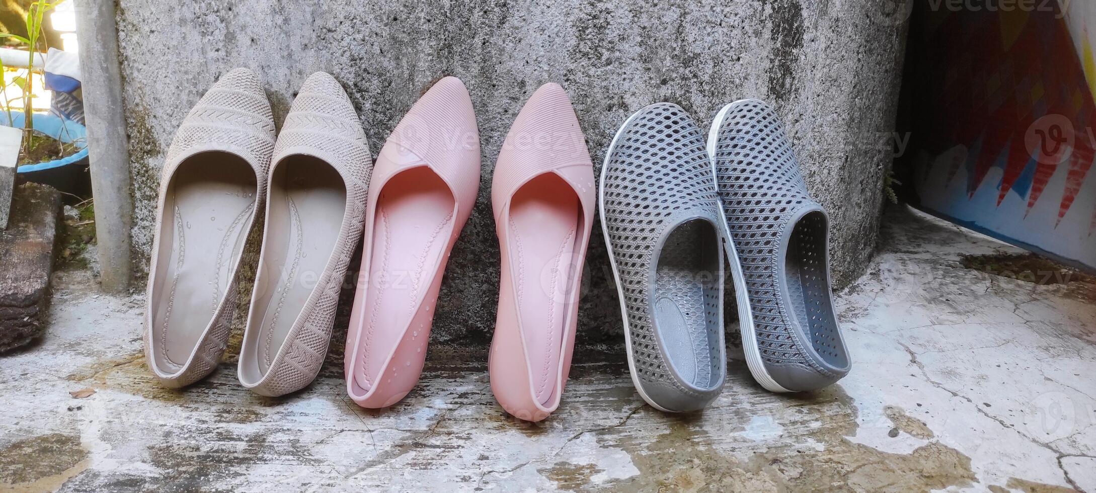 Women's shoes have been washed and are being dried. Woman's shoes standing on cement wall. Various kinds of women's flat shoes. photo