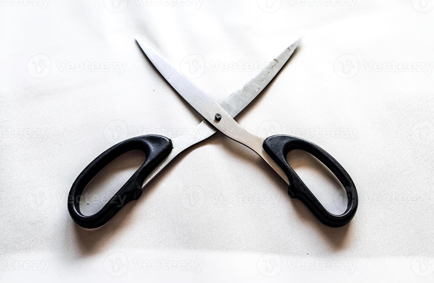 A pair of scissors with a black handle and a white background photo