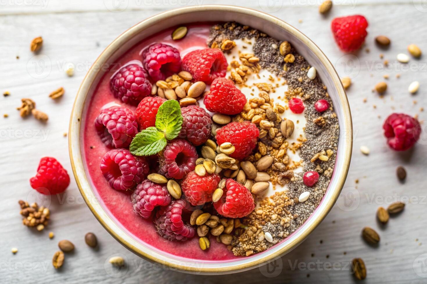A smoothie bowl topped with raspberries, granola, seeds, and chia, captured from a top view on a light background photo