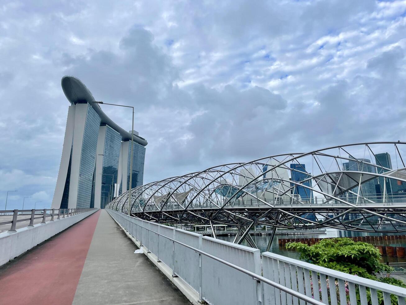 Singapore June 9 2024 The Helix bridge, Marina Bay Sands and Art Science museum with downtown in background during sunset. Marina Bay is famous touristic attraction. photo